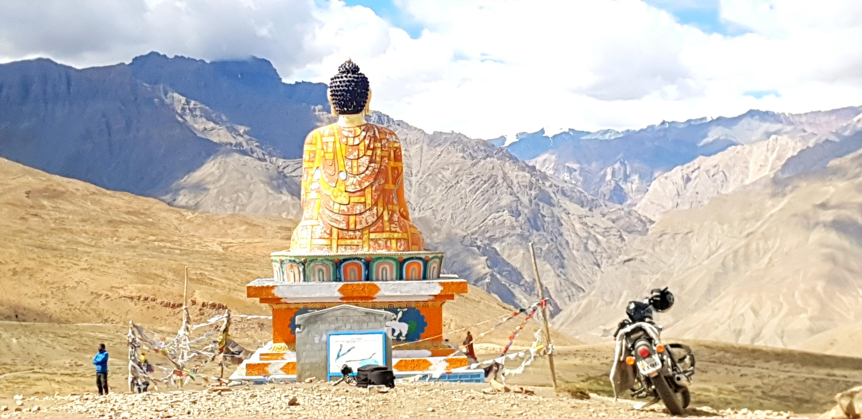 bike parked next to a statue with mountains as backdrop