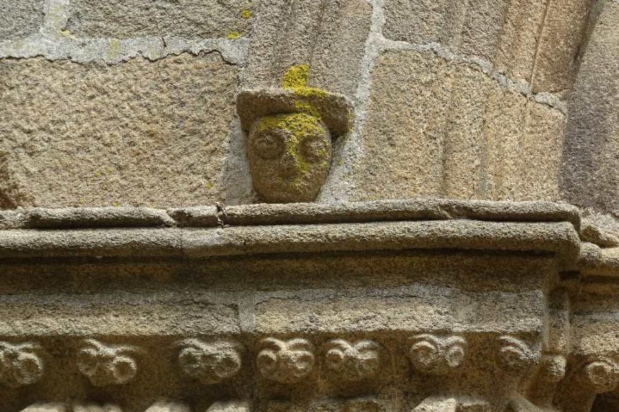 AN ANCIENT STONE CARVED HEAD LOOKING AT OUR BIKE