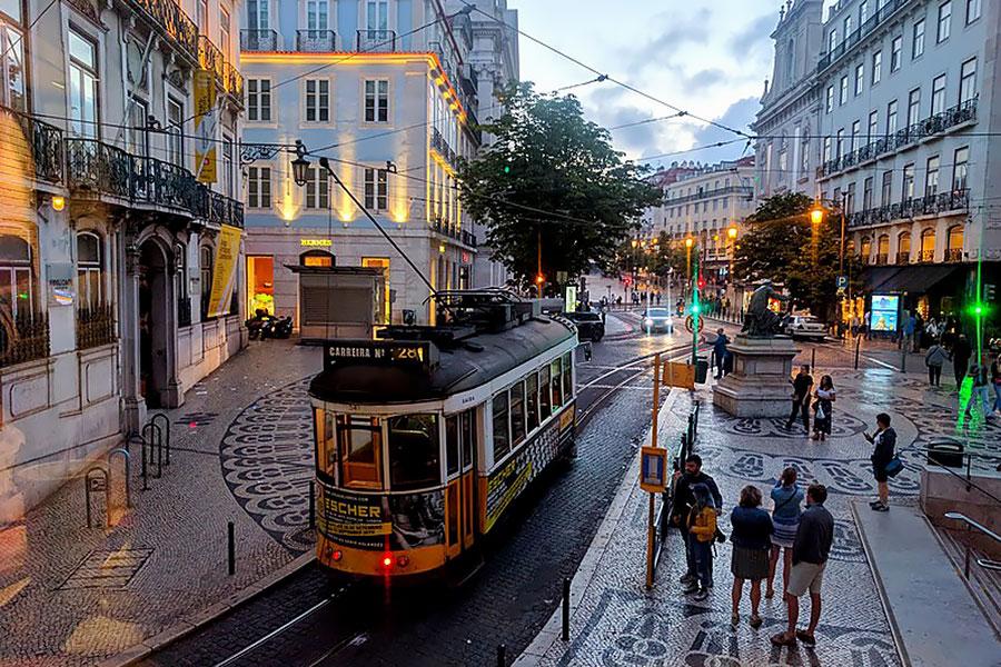 Lisbon Tram 28 on cobblestone street at dusk