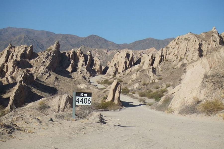 Ruta 40, Argentina - A road sign indicating "KM 4406" on an otherwise unpaved, very rugged, remote dirt road winding its way into rocky spired and mountains.