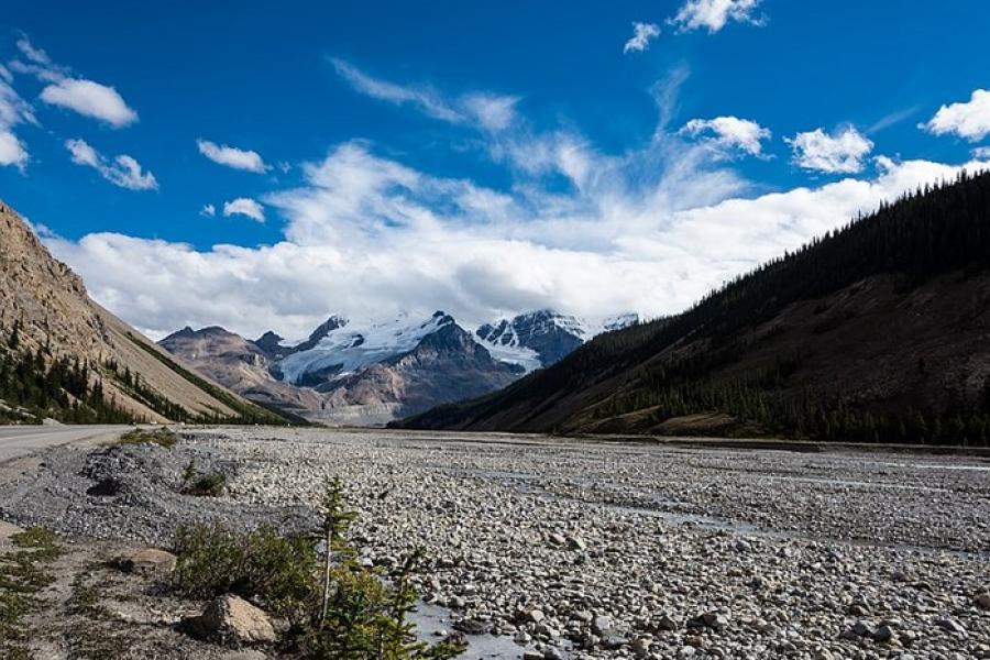 Icefields Parkway - Dried and gravelly river bed with glaciers in the distance. 