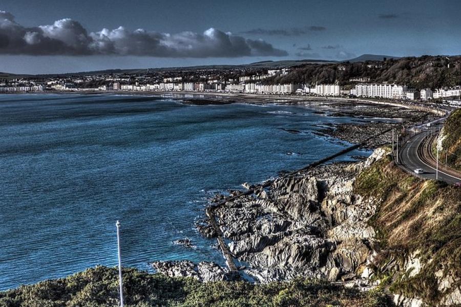 Isle of Man - Shoreline looking toward a small coastal town by the water.